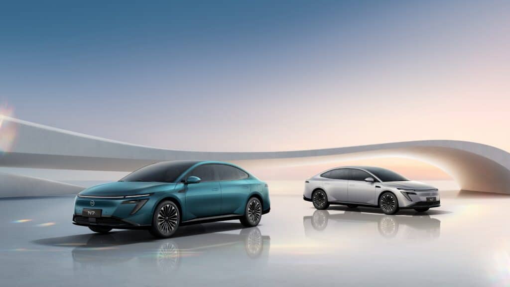 שני רכבי ניסאן N7 EV חשמליים בצבעים לבן וכחול ים עומדים זה לצד זה