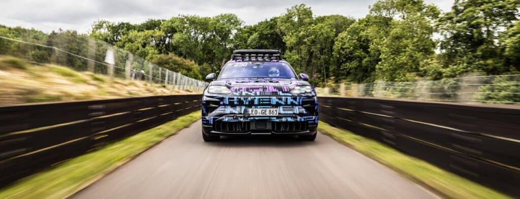 מבט קדמי על פורשה קאיין חשמלית במסלול עם מדבקת הסוואה