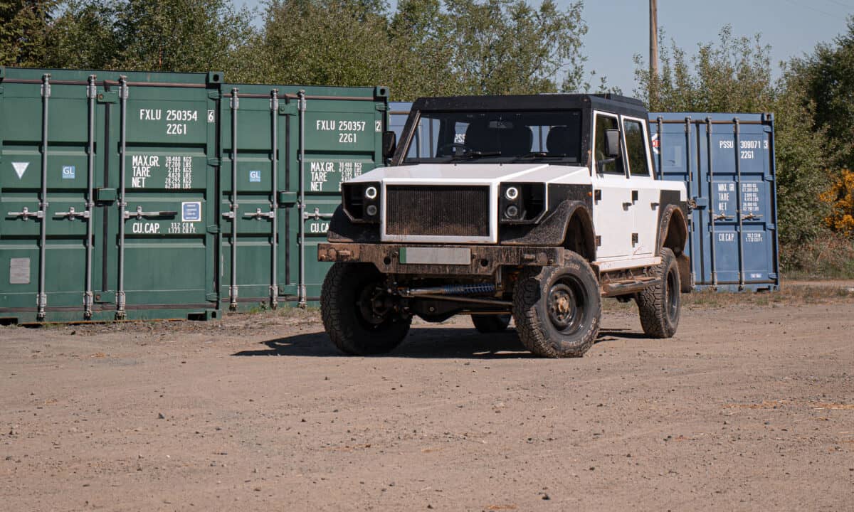 תמונת חזית של רכב שטח חשמלי של מונרו, רכב קופסתי בעל קווים חדים הדומים לדיפנדר, חונה בשטח