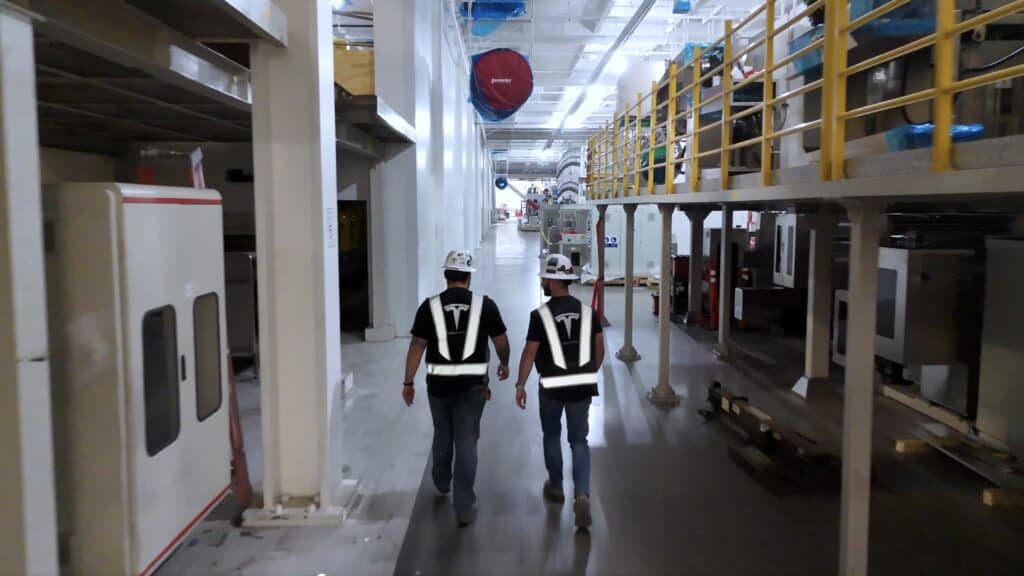 שני עובדים עם ווסט של טסלה במפעל החדש של טסלה