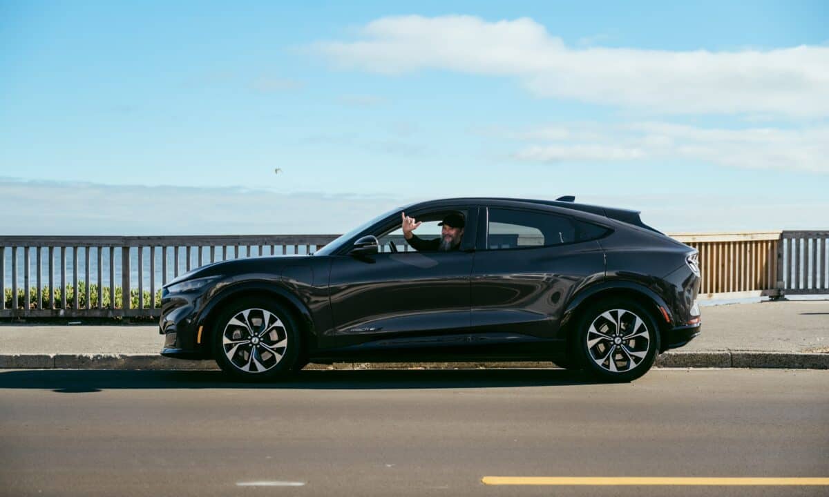 מבט מהצד על מוסטנג מאך E שחורה עם דיוויד בלנקל מאחורי ההגה, לאחר שגמעה מעל 400,000 ק״מ בשירות פרטי בסנטה קרוז