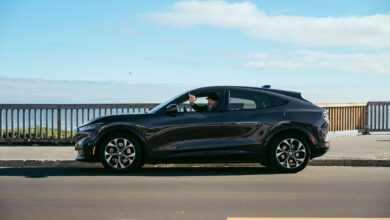 מבט מהצד על מוסטנג מאך E שחורה עם דיוויד בלנקל מאחורי ההגה, לאחר שגמעה מעל 400,000 ק״מ בשירות פרטי בסנטה קרוז