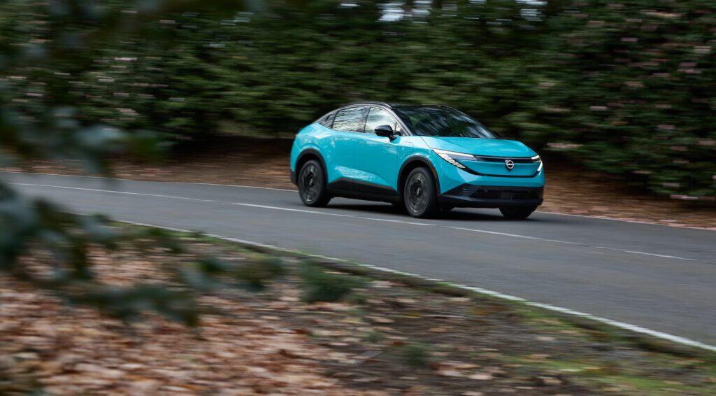 The electric suv is driving down a road.