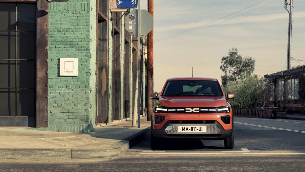 דאצ׳יה ספרינג חשמלי על שפת הכביש עם מבט קדמי, בתוך העיר