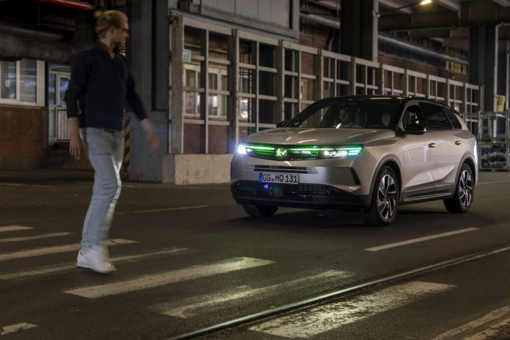 הולך רגל עובר מול אופל גרנדלנד חשמלי שמציג אור ירוק