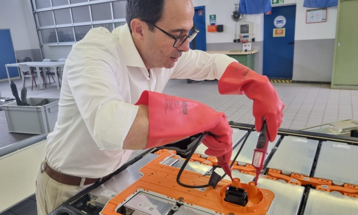 קובי אביטל עובד עם כפפות על סוללת מתח גבוה של רכב חשמלי