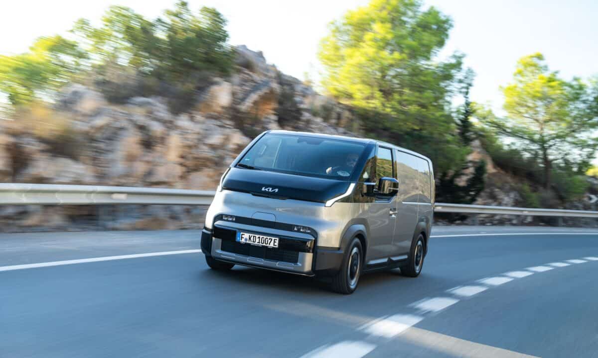 קיה PV5 רכב מסחרי חשמלי בגרסת מטען בצבע אפור פלדה בנסיעה על כביש בינעירוני