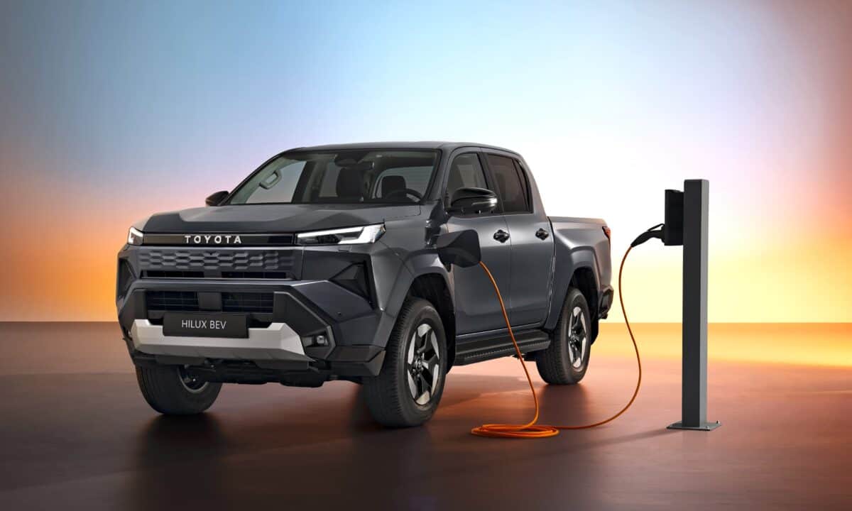 מבט קדמי צדי על טויוטה היילקס חשמלי עם מראה מודרני מחובר לעמדת טעינה איטית