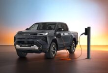 מבט קדמי צדי על טויוטה היילקס חשמלי עם מראה מודרני מחובר לעמדת טעינה איטית